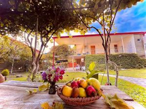 Home Inn-Guesthouse في لاجوديخي: سلة من الفواكه على طاولة مع إناء من الزهور