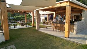 a patio with a bar with tables and chairs at Olympion Sunset Halkidiki in Fourka