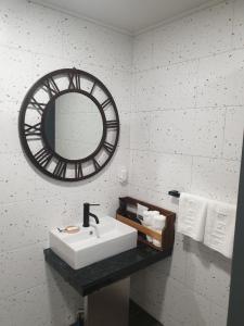 昌原市にあるHotel Giteの洗面台と鏡のある白いバスルーム