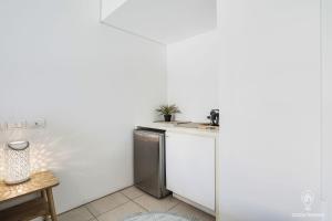 uma pequena cozinha com um lavatório e uma máquina de lavar louça em 602 Harbour Lights with Ocean Views em Cairns
