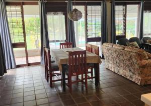 a dining room with a table and chairs and a couch at Villa Serenity welcomes you in Pacific Harbour