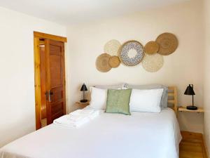 バーリントンにあるCozy 3 Bedroom Getaway with Hot Tubのベッドルーム1室(壁に帽子付きの白いベッド1台付)