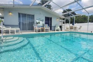 una piscina con sillas y una casa en Entire home with pool & beach 5 min away!, en Englewood