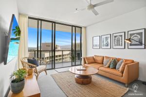 a living room with a couch and a table at 1101 Harbour Lights with Ocean Views in Cairns