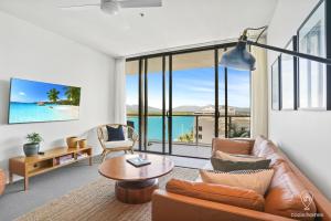 uma sala de estar com um sofá e uma mesa em 1101 Harbour Lights with Ocean Views em Cairns