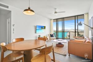 un soggiorno con tavolo e sedie di 1101 Harbour Lights with Ocean Views a Cairns
