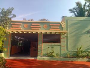 uma casa com uma garagem com um edifício em BANANA FARM HOUSE em Hampi