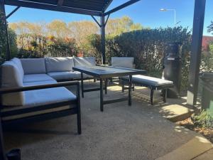 a patio with a couch and a table and chairs at Clock Tower Motor Inn in Coonabarabran