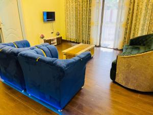 - un salon avec deux canapés bleus et une télévision dans l'établissement Anelie Appartment, à Gisa