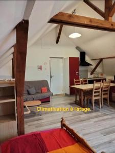 ein Wohnzimmer mit einem Tisch und einem Esszimmer in der Unterkunft gite La Forêt in Ungersheim