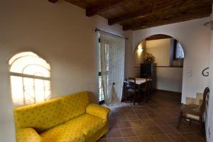 a living room with a yellow couch and a table at Agriturismo Della Pieve in Bardolino
