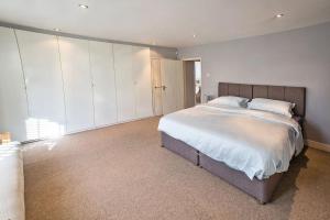 a bedroom with a large bed and white walls at Charming Apartment in Deal near the Beach & Town in Kent