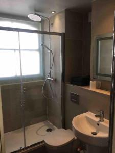a bathroom with a shower and a toilet and a sink at Charming Apartment in Deal near the Beach & Town in Kent