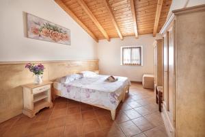 a bedroom with a bed and a vase of flowers at Agriturismo Della Pieve in Bardolino +27 photos