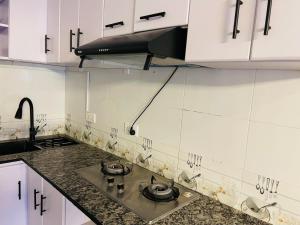 - une cuisine avec des placards blancs et des plaques de cuisson dans l'établissement Anelie Appartment, à Gisa