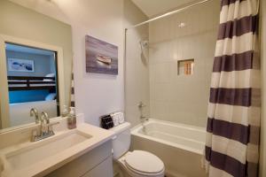 a bathroom with a tub and a toilet and a sink at Luxury Townhome Skyline Views Mins To DT in Nashville