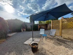 a blue umbrella and two chairs and a table at Virginie & Yann in Saint-Léger-les-Vignes +11 photos