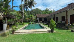 a backyard with a swimming pool and a house at Villa Hiriketiya in Hiriketiya