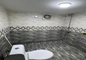 La salle de bains est pourvue d'une douche et de toilettes. dans l'établissement Gold Pine Hotel and Apartments, à Lahore