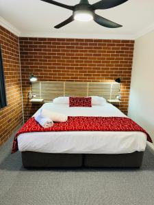 - une chambre avec un grand lit et un mur en briques dans l'établissement The Roseville Apartments, à Tamworth
