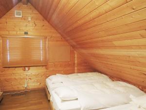 1 dormitorio con 1 cama en una habitación de madera en Kokoro no sato, en Kamishihoro
