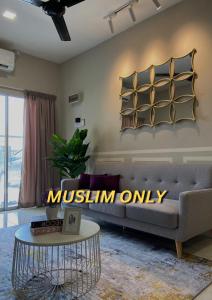 een woonkamer met een bank en een tafel bij Homestay Khan'Da Teluk Intan in Teluk Intan