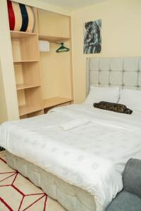 思由基茅Seranade Suites的卧室配有白色的大床和架子