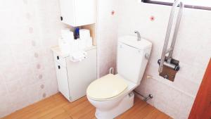 La salle de bains est pourvue de toilettes blanches. dans l'établissement さつきあん, à Île Miyako