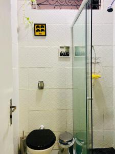 um banheiro com vaso sanitário e chuveiro de vidro em Galeria SP Hostel em São Paulo