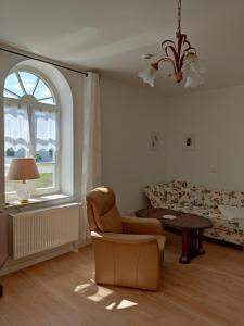 sala de estar con silla y sofá en Inspektorenhaus Dobbin Ferienpension, en Linstow