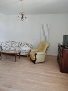 sala de estar con sofá, silla y mesa en Inspektorenhaus Dobbin Ferienpension en Linstow