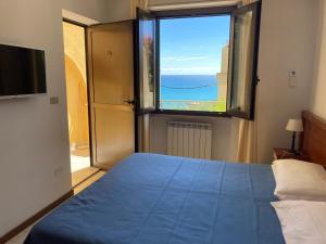 um quarto com uma cama azul e uma grande janela em Ulivo em Diano Marina