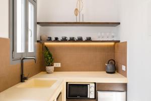 a kitchen with a sink and a microwave on a counter at Captain's house suites in Vóthon