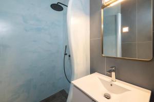 Vóthon的住宿－Captain's house suites，浴室配有盥洗盆和带镜子的淋浴