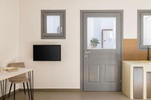 um quarto com uma porta e uma televisão na parede em Captain's house suites em Vóthon