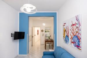 sala de estar con sofá azul y TV en Appartamento Cortese, en San Vito lo Capo