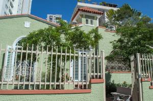 una cerca frente a una casa verde en Casa Isabel B&B en San Juan