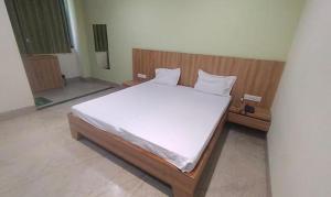 Schlafzimmer mit einem großen Bett mit einem Kopfteil aus Holz in der Unterkunft FabHotel Park Mahindra in Raipur