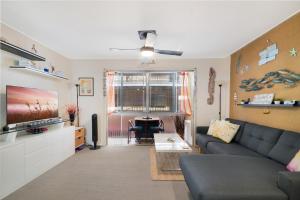 sala de estar con sofá y TV en Two-bedroom Beachside Apartment with Parking en Gold Coast