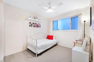 a white bedroom with a bed and a window at Two-bedroom Beachside Apartment with Parking in Gold Coast