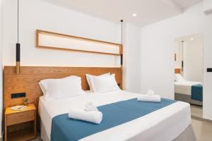 a bedroom with a large bed with towels on it at Diamond Star Hotel in Falasarna