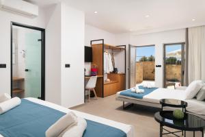 a hotel room with two beds and a desk at Diamond Star Hotel in Falasarna