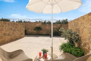 a table with an umbrella on a patio at Diamond Star Hotel in Falasarna