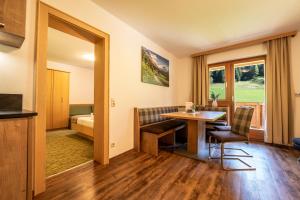 una habitación de hotel con una mesa y sillas y un dormitorio en Oberlehenhof, en Kaprun