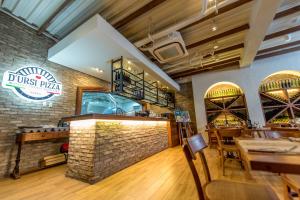 a restaurant with a dining area with a brick wall at Hotel 1925 in Lipa