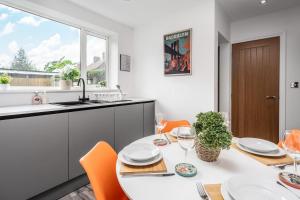 - une cuisine blanche avec une table, des chaises et un évier dans l'établissement Shawe House - 10 minute Mcr Airport - Free Parking, à Wythenshawe