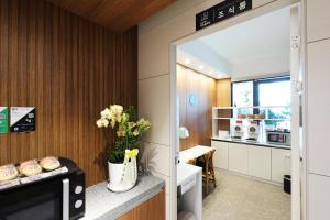 a kitchen with a vase of flowers on a counter at Jeonju Urban Hotel in Jeonju