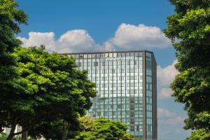 Jeju Bolton Hotel في جيجو: مبنى زجاجي طويل مع علامة جوجل عليه