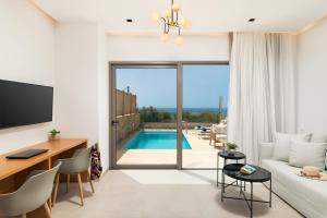 a bedroom with a desk and a living room with a pool at Diamond Star Hotel in Falasarna