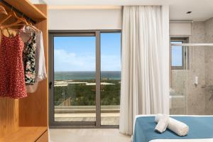a bedroom with a bed and a large window at Diamond Star Hotel in Falasarna